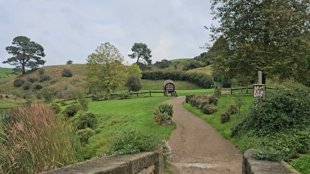 Winding path through the green hills and gardens of Hobbiton in New Zealand.