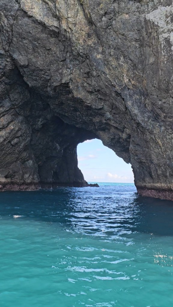 Natural rock arch over blue ocean in Bay of Islands, New Zealand