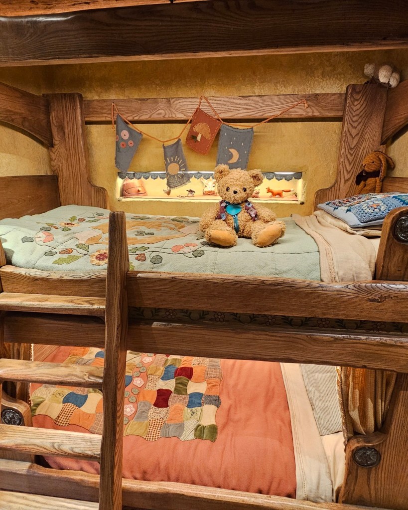 Patch enjoying his comfy spot on the top bunk of a childs bunkbed.